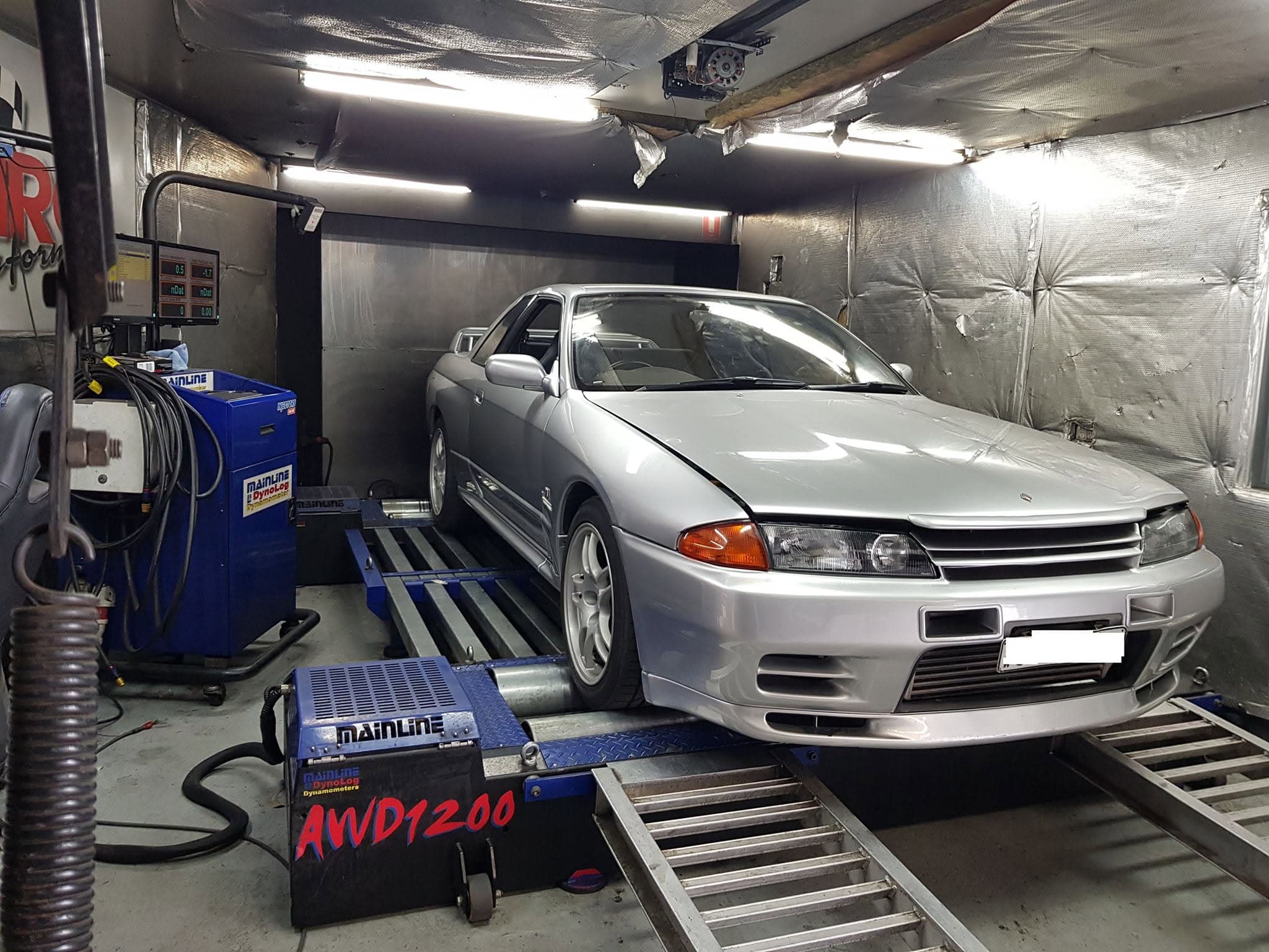 A white Nissan Silvia S15 strapped to the dyno at MRC Dyno, cooling fan in front
