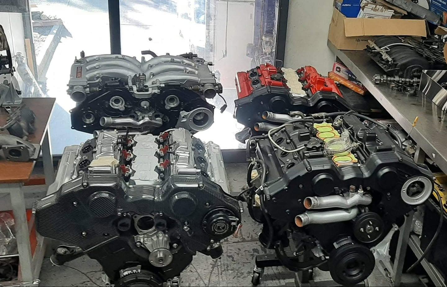 Four V engines on stands at MRC Dyno, including one with carbon fibre covers, waiting on assembly