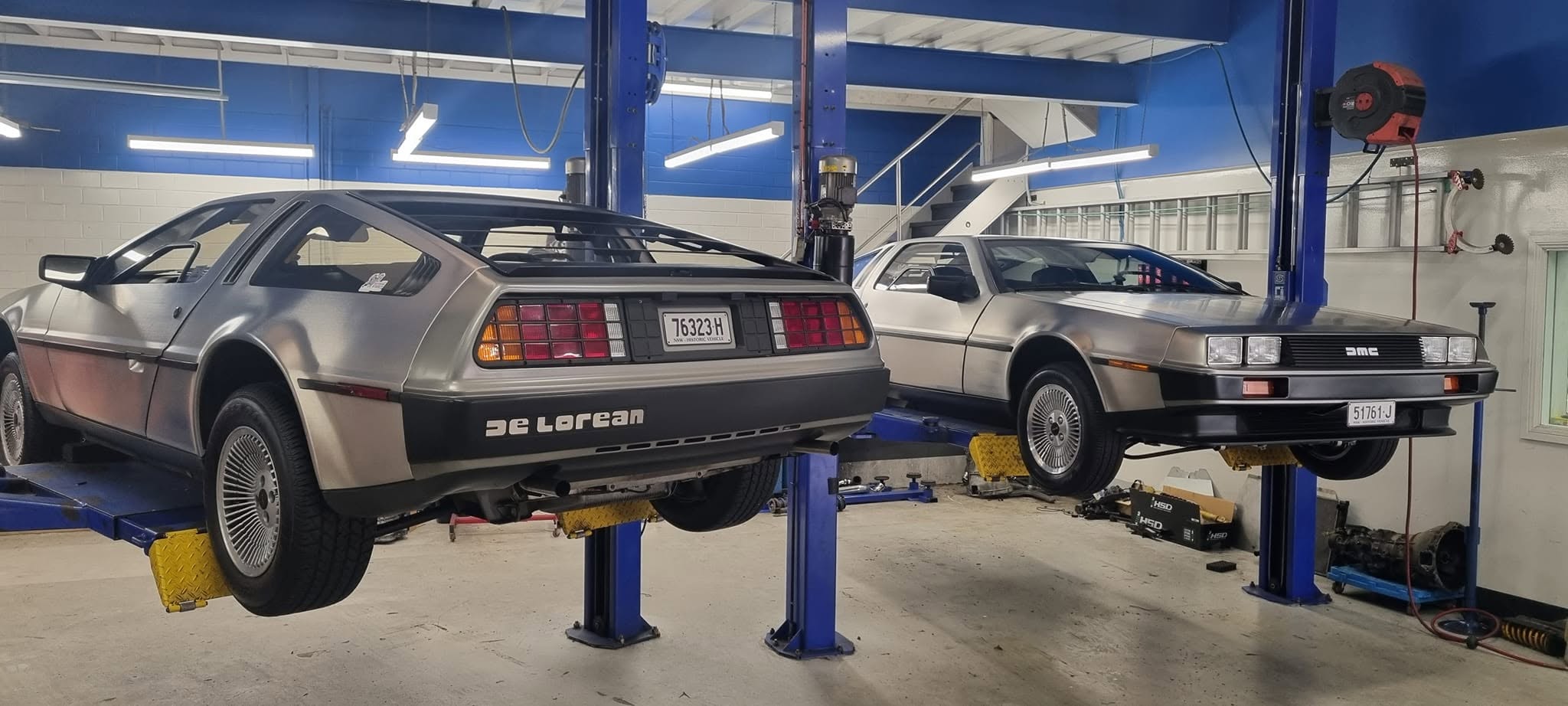 Two DeLorean DMC-12s up on the hoists at MRC Dyno